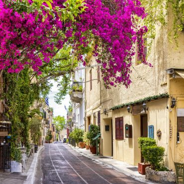 Beautiful view to the little streets of the old town Plaka of Athens, Greece with colorful houses and blooming bougainvillea flowers