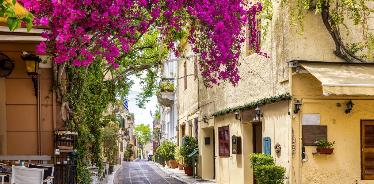 Beautiful view to the little streets of the old town Plaka of Athens, Greece with colorful houses and blooming bougainvillea flowers